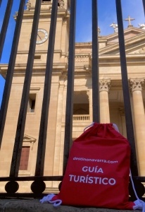 Mochila roja de guía turístico local de Destino Navarra